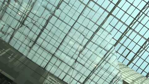 Beautiful glass ceiling and elevator of big shopping mall with cloud sky through Stock Footage 249014028