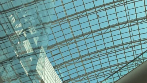 Beautiful glass ceiling and elevator of big shopping mall with cloud sky through Stock Footage 249604509