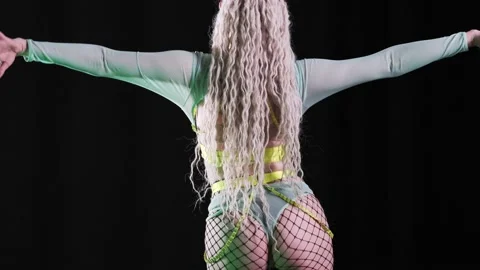 Beautiful go-go dancer with dreadlocks in a sexy costume beautifully spreads her Stock Footage 235961540