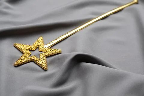 Beautiful golden magic wand on grey fabric Stock Photos