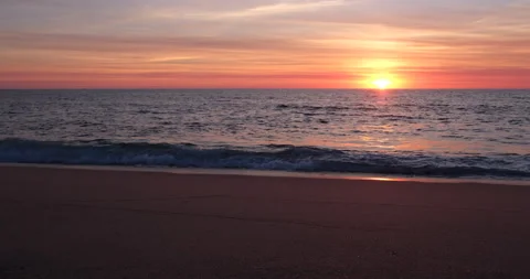Beautiful golden sunset on empty beach. Pan right along shoreline. Video stock 139534116