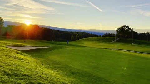 Beautiful Golf Course with Putting Green and Mountain View in Sunset with Lens Stock Footage 334012108