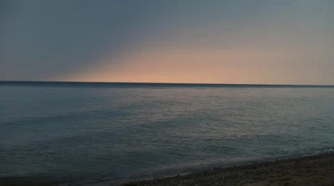 Beautiful gradiant in the sky as the sun sets over calm waves on Lake Michigan Stock Footage 52491024