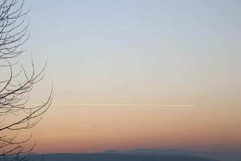 Beautiful gradient sunset with trace of plane. Stock Photos