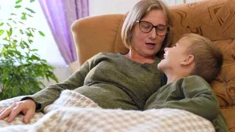 Beautiful grandma having fun hugging, laughing and playing with grandson at home Stock Footage 232925619
