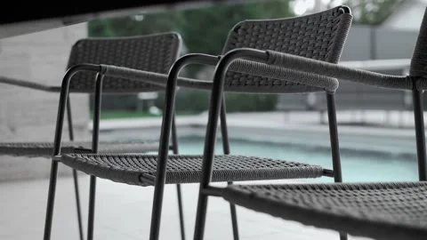 Beautiful gray wicker chairs in the backyard of a country house by the pool Stock Footage 220774006