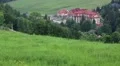 Beautiful green meadows and hotel building with red roof HD Footage