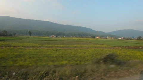 Beautiful green paddy fields, mountains and houses during sunset. Stock Footage 127707765