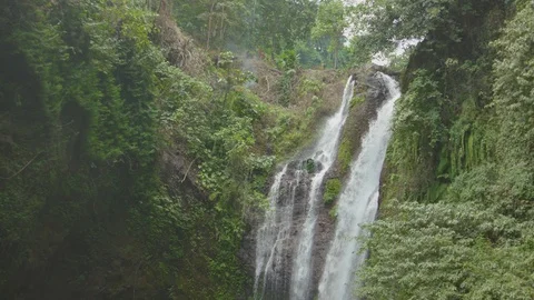 Beautiful gushing waterfall flowing through the lush mountain Vídeo Stock 87395945
