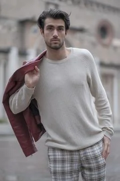 Beautiful guy with red leather jacket and backpack in the center of reggio em Stock Photos