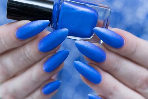 Beautiful hand with long nails and bright blue manicure Stockfoto's