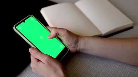 Beautiful hands of a girl leaf through the tape on the phone against. Stock Footage 193080394
