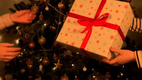 Beautiful hands give a gift on the background of the Christmas tree. Paper stars Stock Footage 120134062