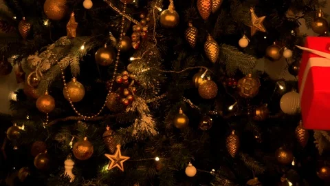 Beautiful hands give a gift on the background of the Christmas tree. Red gift  Stockbeeldmateriaal 120134138