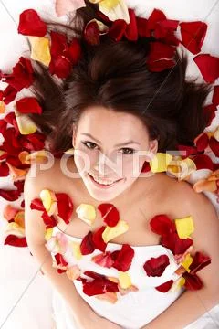 Beautiful happy girl in rose petal. spa . Stock Photos