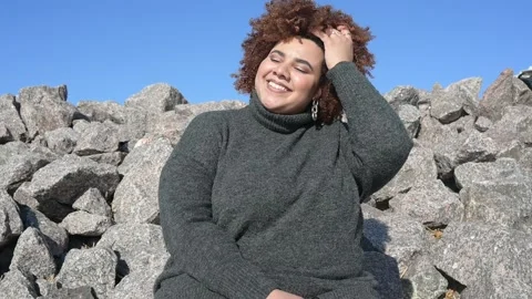Beautiful happy smiling plus size African black woman afro hair in grey sweater Stock Footage 153420564