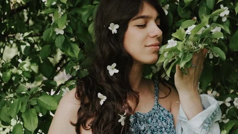 Beautiful happy young dark-haired woman enjoys blooming apple trees. Stock Footage 199241058