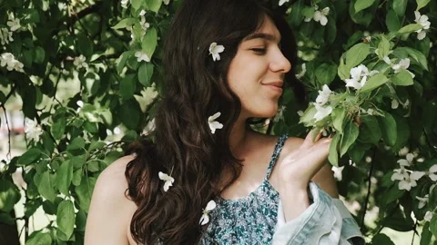 Beautiful happy young dark-haired woman enjoys blooming apple trees. Stock Footage 199241131