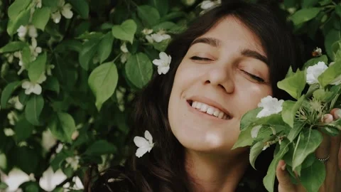 Beautiful happy young dark-haired woman enjoys blooming apple trees. Stock Footage 199241135