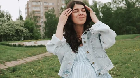 Beautiful happy young dark-haired woman enjoys the summer rain in the park. Stock Footage 199241629