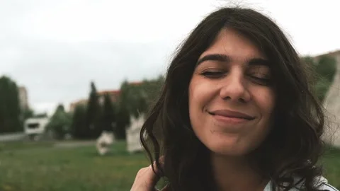 Beautiful happy young dark-haired woman enjoys the summer rain in the park. Stock Footage 199241687
