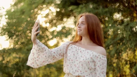 Beautiful happy young pipe-haired girl making a video call, smiling, talking Stock Footage 235032552