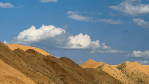 Beautiful heap clouds on the blue sky moving over sandy hills in the form of Stock Footage 93556247