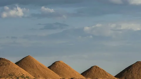 Beautiful heap clouds on the blue sky moving over sandy hills in the form of Stock Footage 93556656