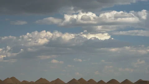 Beautiful heap clouds on the blue sky moving over sandy hills in the form of Stock Footage 93556816