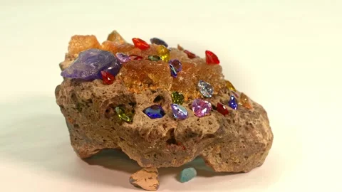 Beautiful Heart-shaped diamonds in various colors set on a raw opal gemstone  Stock Footage 253023008