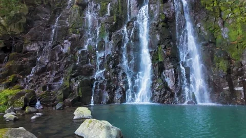 Beautiful Hidden Waterfall Flowing into a Crystal Clear Pool Stock Footage 336593165