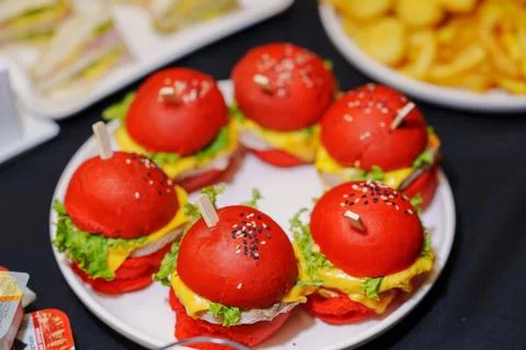 Beautiful high angle view of six red mini burgers on a white buffet plate Stock Photos