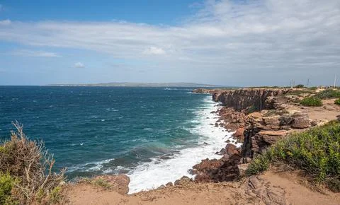 The beautiful high red cliffs of Macor on the island of Sant'Antioco in Sar.. Stock Photos