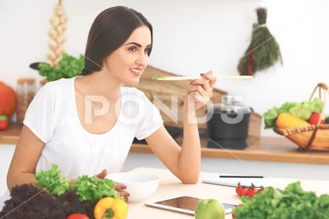Beautiful Hispanic or latin american woman is holding wooden spoon while cookin Stock Photos