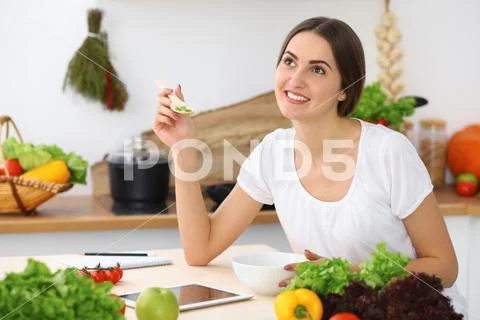 Beautiful Hispanic or latin american woman is holding wooden spoon while cookin Stock Photos