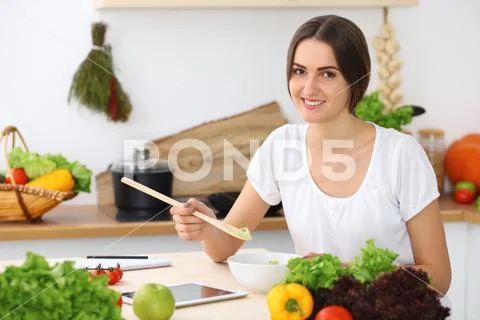 Beautiful Hispanic or latin american woman is holding wooden spoon while cookin Stock Photos