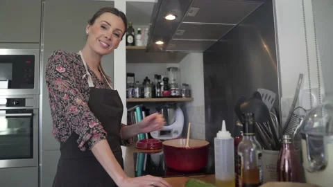Beautiful home chef standing by kitchen stove Stock Footage 151002235