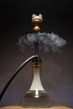 Beautiful hookah with a transparent flask in a cloud of white smoke Stock Photos