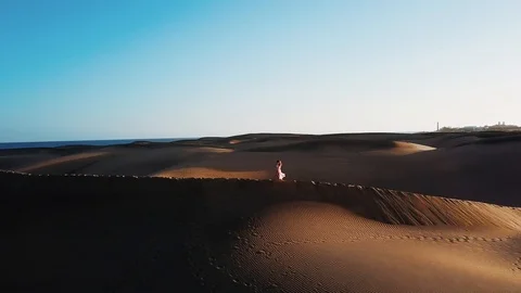 Beautiful horizontal landscape with desert, blue sky and the ocean behind. Woman Stock Footage 95003569