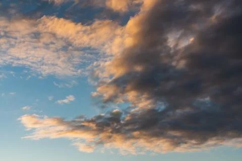 A beautiful horizontal texture of a blue sky with bright white and orange and Stock Photos