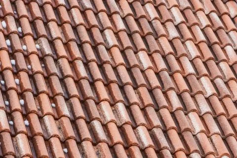 A beautiful horizontal texture of part of an old wet brown roof of clay tiles Foto stock