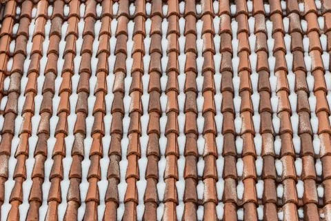 A beautiful horizontal texture of part of an old wet brown roof of clay tiles Stock Photos