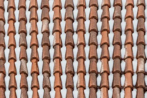 A beautiful horizontal texture of part of an old wet brown roof of clay tiles Foto stock