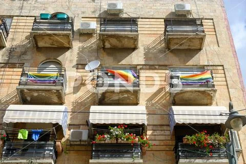 A beautiful house with balconies on which flags of the gay community hang Stock Photos