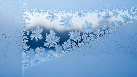 Beautiful ice crystal patterns forming on a cold glass window during a free.. Fotos de archivo