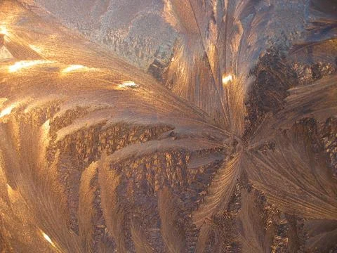 Beautiful ice pattern and sunlight closeup on window glass Stock Photos