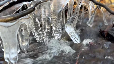 Beautiful icicle formations during the freezing of the stream in winter Stock Footage 296653075