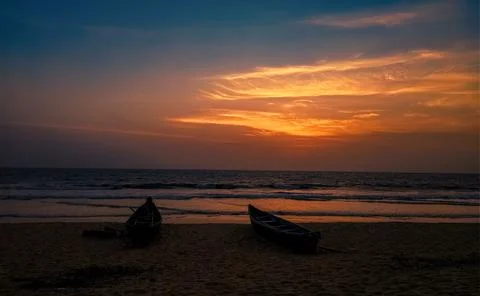 Beautiful Indian beach at the evening with dramatic sky and silhouette boat.. Stock Photos