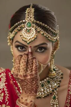 Beautiful Indian bride putting a bindi on the forehead	 Stock Photos
