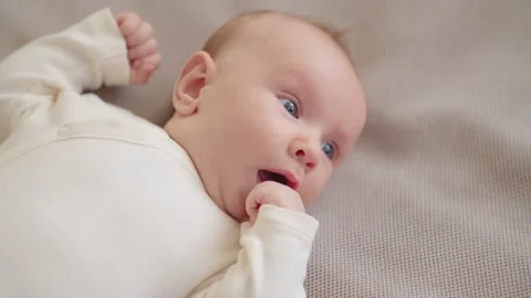Beautiful infant. Cute two-month-old baby in blue clothes looks into  camera, Stock Footage 163961331